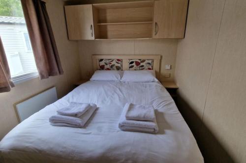 a bed in a small room with towels on it at HO48 - Coghurst Hall - Hastings, East Sussex in Westfield