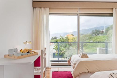 a bedroom with a bed and a large window at THE OLD CHAPEL HOUSE in Funchal