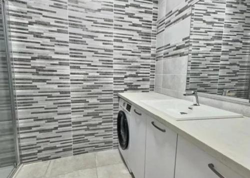 a white washing machine in a bathroom with a shower at Bel ppartement en plein Centre ville in Valras-Plage