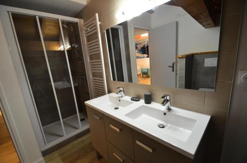 La salle de bains est pourvue d'un lavabo blanc et d'une douche. dans l'établissement Chalet Barthelemy - 3 Pièces pour 4 Personnes 204, à Saint-Martin-de-Belleville