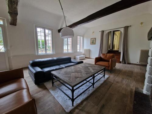 a living room with a couch and a coffee table at Maison spacieuse - Piscine - Jardin 