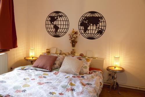 a bedroom with a bed with three globe clocks on the wall at B&B la récré de Bauffe in Bauffe