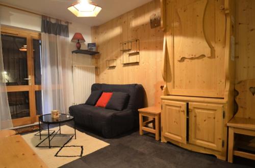 - un salon avec un canapé noir et une armoire dans l'établissement Résidence Jetay - Studio 4 personnes au Ménuires avec vue sur la Masse MAE-4214, aux Menuires
