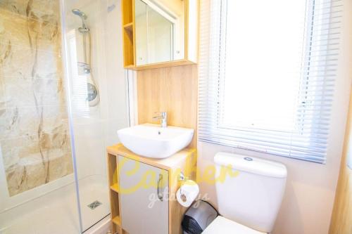 uma casa de banho com um WC, um lavatório e um chuveiro em MP753 - Camber Sands Holiday Park - Sleeps 6 em Camber