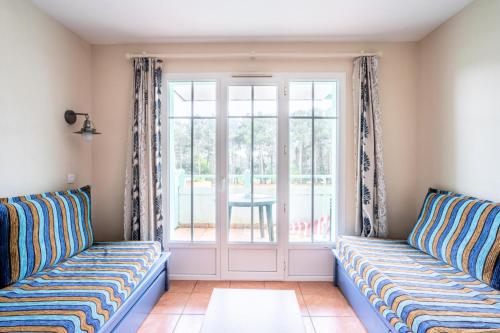 un salon avec deux canapés et une fenêtre dans l'établissement Résidence Lacanau Les Pins - maeva Home - Appartement 2 Pièces 5 Personnes - Sélection MAE-2324, à Lacanau