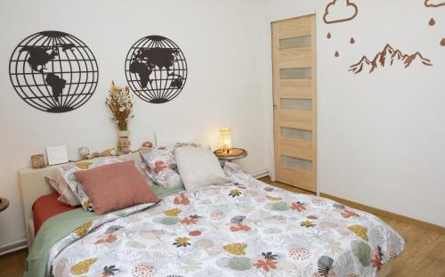 1 dormitorio con 1 cama y 2 relojes globos en la pared en B&B la récré de Bauffe 