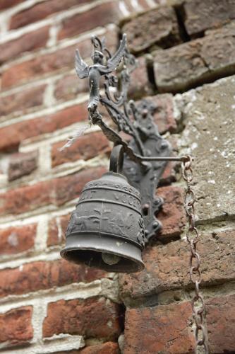 a bell on the side of a brick building at B&B la récré de Bauffe in Bauffe
