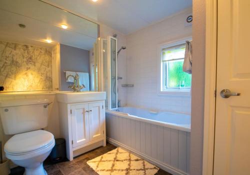 La salle de bains est pourvue de toilettes, d'une baignoire et d'un lavabo. dans l'établissement 11 The Oaks - Lodge - Coghurst Hall - Hastings, à Westfield