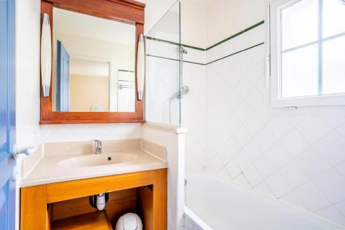 une salle de bain blanche avec un lavabo et une douche dans l'établissement Les Maisons de Lacanau les Pins - maeva Home - Maison 3 Pièces 4 Personnes - Sélection MAE-2364, à Lacanau