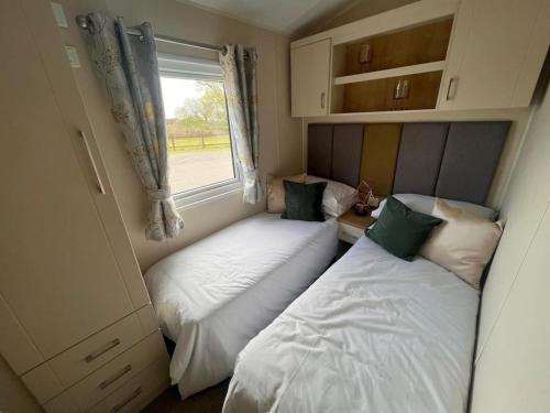 two beds in a small room with a window at BH14 - Marlie Holiday Park - New Romney in Kent