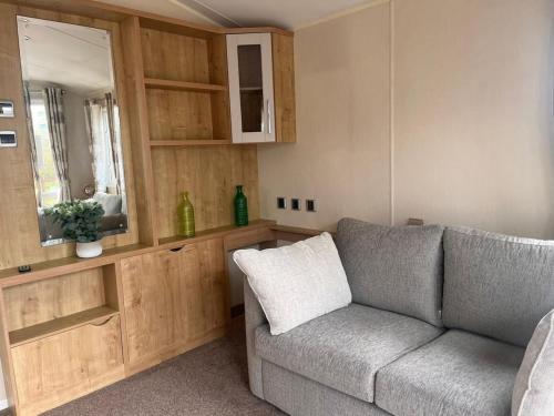 a living room with a couch and a mirror at BH14 - Marlie Holiday Park - New Romney in Kent
