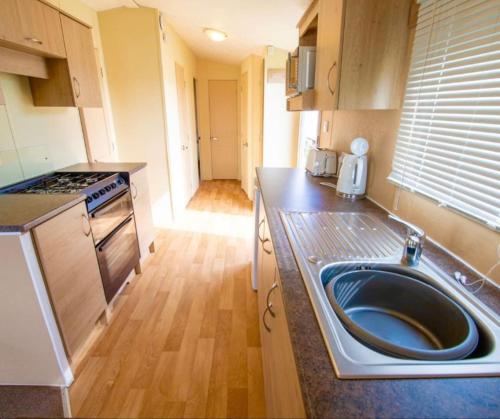 a kitchen with a sink in the middle of it at MP252 - Camber Sands Holiday Park - Central Spot in Camber