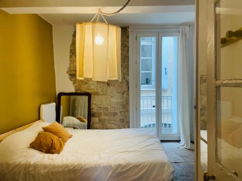 - une chambre avec un lit aux murs jaunes et un miroir dans l'établissement Centre historique Montpellier, à Montpellier