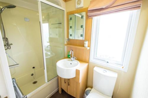 Kylpyhuone majoituspaikassa SP143 Mini Lodge - Camber Sands Holiday Park - Sleeps 6 - Bath - Washing Machine - Private Parking
