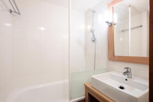 une salle de bain blanche avec un lavabo et une douche dans l'établissement Résidence Port du Crouesty - maeva Home - Appartement 2 Pièces 5 Personnes avec mezzanine - Confort MAE-1844, à Arzon