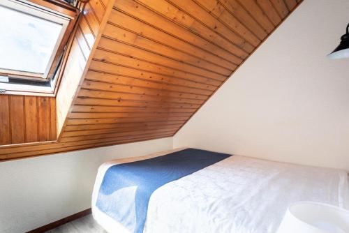 une chambre avec un lit et un plafond en bois dans l'établissement Résidence Port du Crouesty - maeva Home - Appartement 2 Pièces 5 Personnes avec mezzanine - Confort MAE-1844, à Arzon