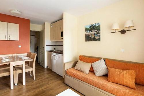 un salon avec un canapé orange et une cuisine dans l'établissement Résidence Cannes Villa Francia - maeva Home - Appartement 2 Pièces 4 Personnes - Confort MAE-4184, à Cannes