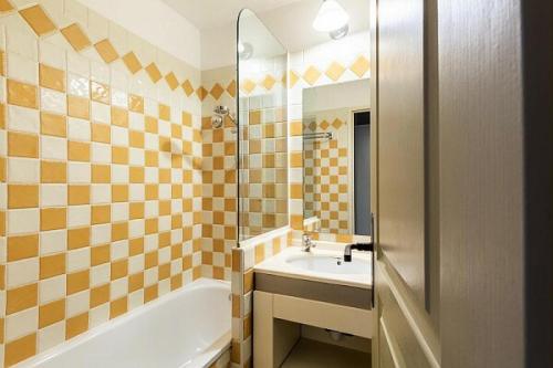 une salle de bain avec une baignoire et un lavabo et une baignoire dans l'établissement Résidence Cannes Villa Francia - maeva Home - Appartement 2 Pièces 4 Personnes - Confort MAE-4184, à Cannes
