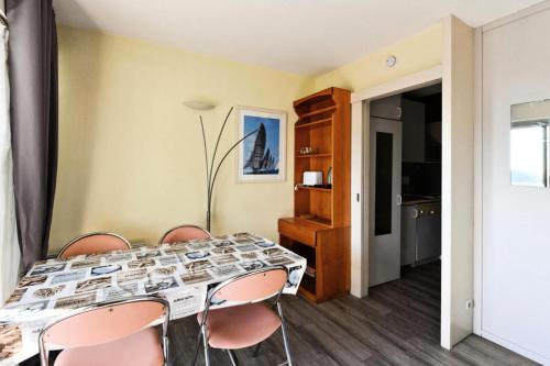 une salle à manger avec une table et quatre chaises dans l'établissement Hyeres Parc - maeva Home - Appartement 2 pièces 6 Personnes Confort MAE-5114, à Hyères
