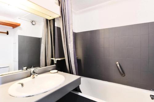 une salle de bain avec un lavabo et une baignoire dans l'établissement Hyeres Parc - maeva Home - Appartement 2 pièces 6 Personnes Confort MAE-5114, à Hyères