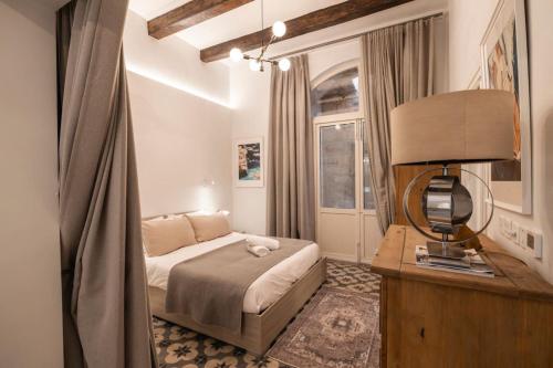 a bedroom with a bed and a table with a lamp at Harbour Mansion in Birgu
