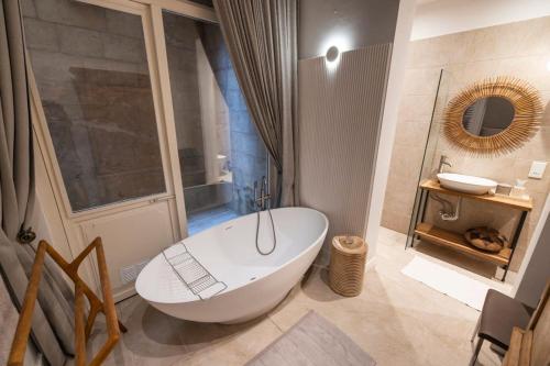 a bathroom with a large white tub and a sink at Harbour Mansion in Birgu