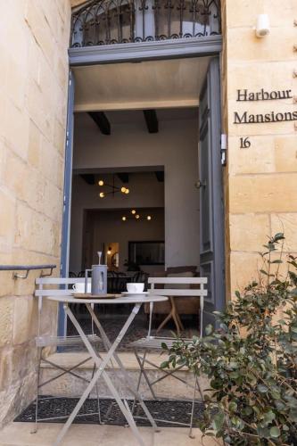 a table in front of a building with a sign at Harbour Mansion in Birgu