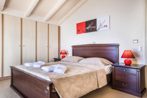 a bedroom with a large bed with towels on it at Villa Vlachata Emerald in Vlachata