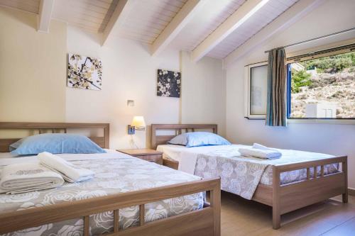 a bedroom with two beds and a window at Villa Vlachata Emerald in Vlachata