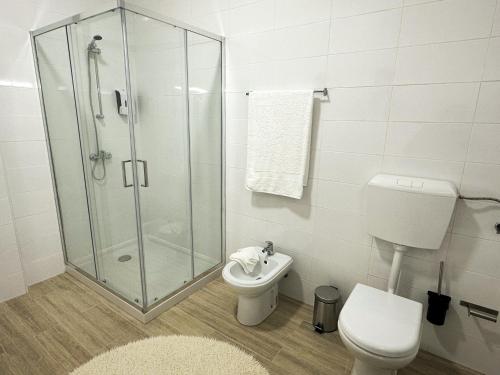 a bathroom with a shower and a toilet and a sink at Largo das Calçadas in Porto de Mós