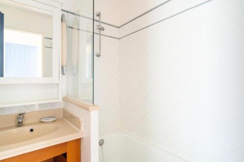 une salle de bain avec une baignoire, un lavabo et un miroir dans l'établissement Résidence Lacanau Les Pins - maeva Home - Appartement 2 Pièces 4 Personnes - Prestige MAE-2614, à Lacanau