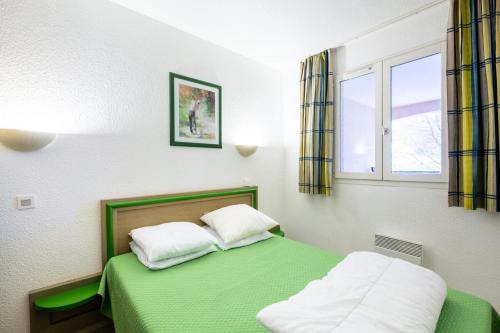 une chambre avec un lit vert et une fenêtre dans l'établissement Résidence Saint-Raphaël Valescure - maeva Home - Appartement 2 Pièces 6 Personnes - Sélection MAE-1874, à Valescure
