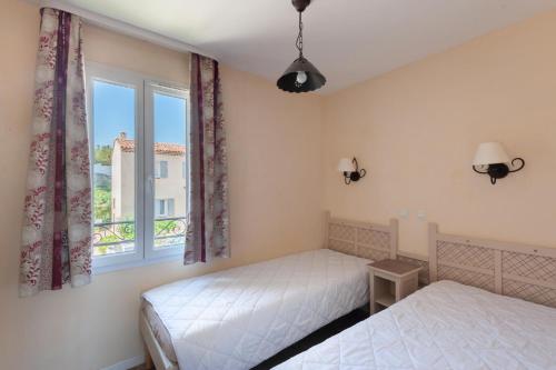 deux lits dans une chambre avec une fenêtre dans l'établissement Les Coteaux de Pont Royal en Provence - maeva Home - Maison 3 Pièces 6 Personnes - Sélection MAE-7944, à Mallemort