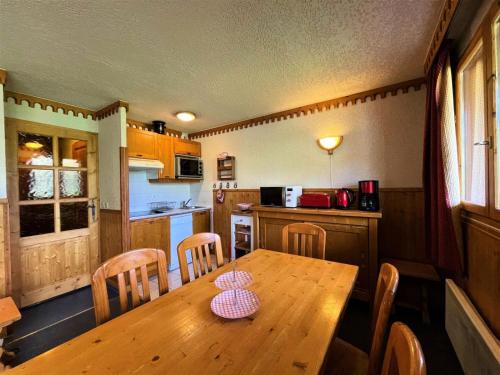 une cuisine avec une table et des chaises en bois dans l'établissement Résidence Bosson - Appartement 6 personnes ski aux pieds MAE-4584, aux Menuires