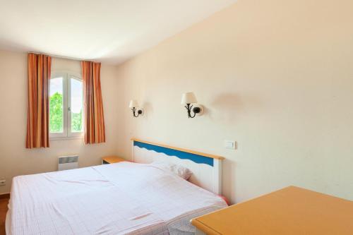 a bedroom with a bed and a table and a window at Les Maisons de Pont Royal en Provence - maeva Home - Maison 4 Pièces 8 Personnes climatisée - Confort MAE-0094 in Mallemort