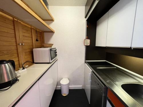 une petite cuisine avec un évier et un micro-ondes dans l'établissement Résidence Chaviere - Appartement pour 4 personnes avec balcon exposé Sud MAE-4604, aux Menuires