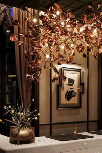 a chandelier hanging over a table with a plant at Hotel Sosei Sapporo MGallery Collection in Sapporo