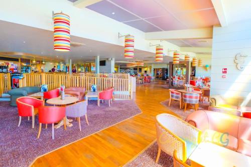 Un restaurante con mesas y sillas en un centro comercial. en SBL19 - Parkdean Resorts, Camber Sands, en Camber