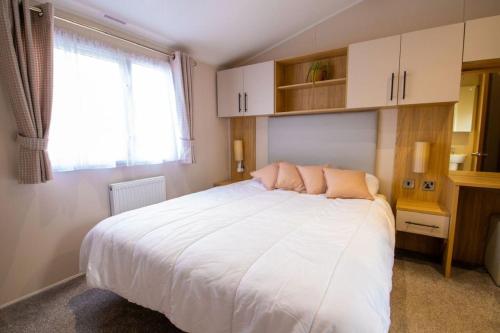 Un dormitorio con una gran cama blanca y una ventana en 35 Redwood - Beauport Park, Hastings, en Hastings
