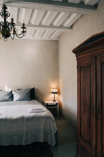 a bedroom with a bed and a table with a lamp at Kalnciema kvartāla Kuldīgas rezidence in Kuldīga