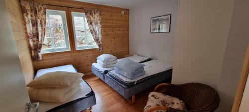 a small room with two beds and a window at Hausvikstranda in Lyngdal