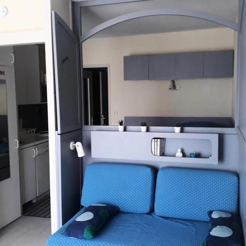 une chambre avec un canapé bleu dans une cuisine dans l'établissement Hyeres Parc - maeva Home - Studio 4 Personnes Confort MAE-5104, à Hyères