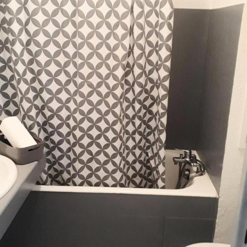 La salle de bains est pourvue d'un rideau de douche noir et blanc. dans l'établissement Hyeres Parc - maeva Home - Studio 4 Personnes Confort MAE-5104, à Hyères