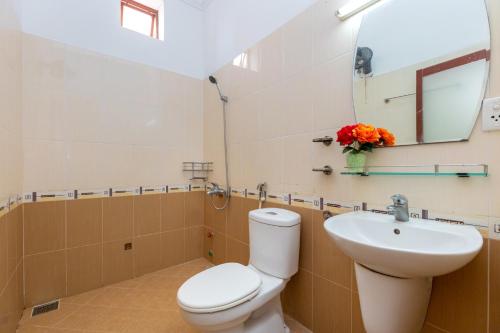 a bathroom with a toilet and a sink and a mirror at Homestay Bảo Anh in Vung Tau