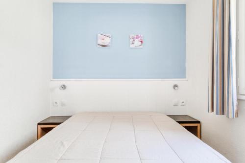 une chambre blanche avec un lit et une fenêtre dans l'établissement Résidence Port du Crouesty - maeva Home - Appartement 2 Pièces 4 Personnes - Confort MAE-6454, à Arzon