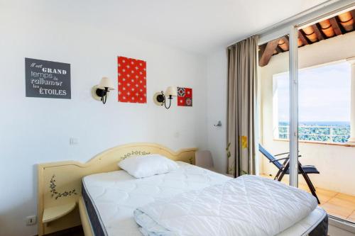- une chambre avec un lit et une fenêtre dans l'établissement Les Appartements aux Restanques du Golfe de St Tropez - maeva Home - Appartem 04, à Grimaud