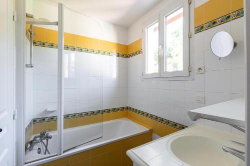 La salle de bains est pourvue d'une baignoire et d'un lavabo. dans l'établissement Les Appartements aux Restanques du Golfe de St Tropez - maeva Home - Appartem 04, à Grimaud