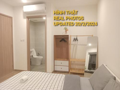 a room with a bed and a mirror and a bathroom at FThomestay at Vinhome Grand Park HCM in Gò Công
