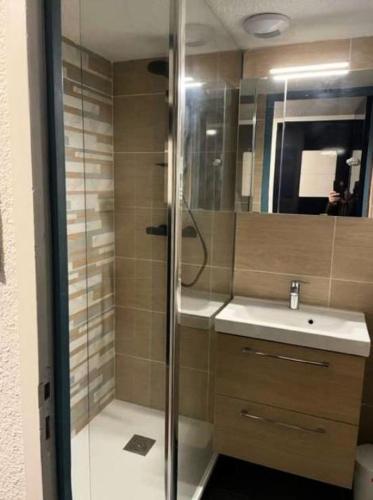 une salle de bain avec une douche, un lavabo et un miroir dans l'établissement Résidence Port du Crouesty - maeva Home - Appartement 2 pièces 4 personnes - Budget MAE-7994, à Arzon
