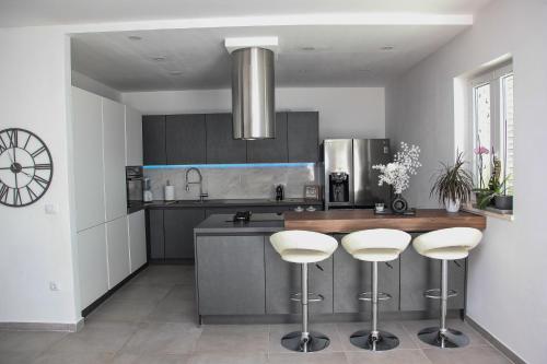 a kitchen with a counter with three bar stools at Villa Rita in Orebić